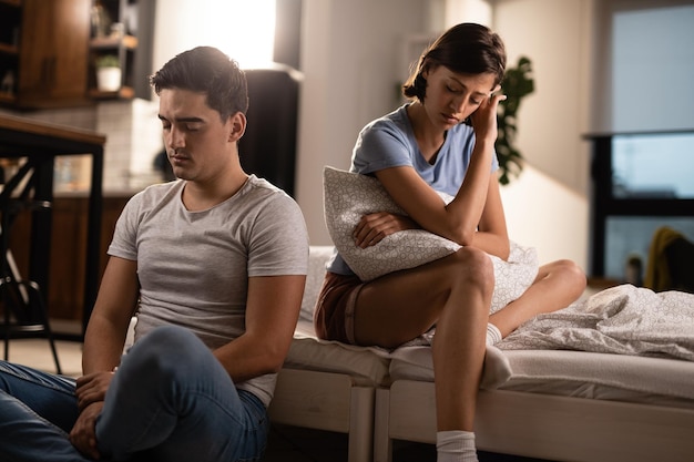 Jeune couple mécontent s'ignorant après une dispute dans la chambre