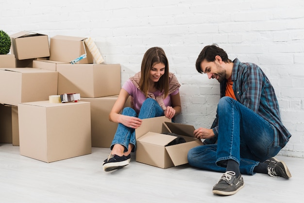 Jeune couple ouvrant les cartons dans leur nouvelle maison