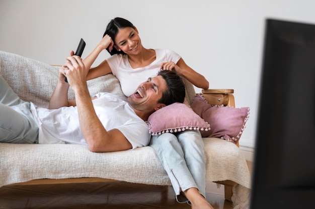 Photo gratuite jeune couple passe du temps devant la télé