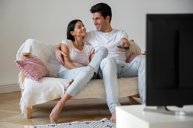 Photo gratuite jeune couple passe du temps devant la télé