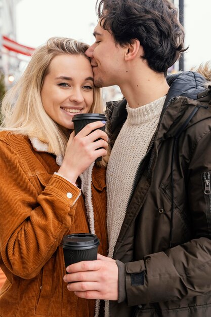 Jeune couple en plein air appréciant une tasse de café