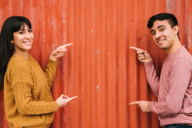 Jeune couple pointant vers la clôture orange