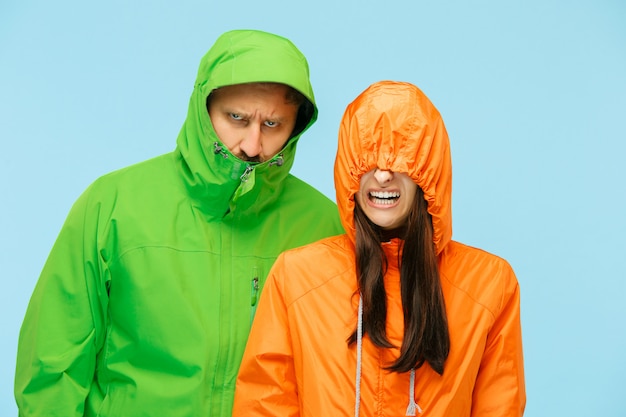 Photo gratuite jeune couple, poser, à, studio, dans, automne, vestes, isolé, sur, bleu