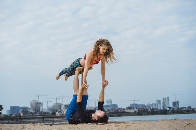 jeune couple, pratiquer, yoga, sur, ville, arrière-plan