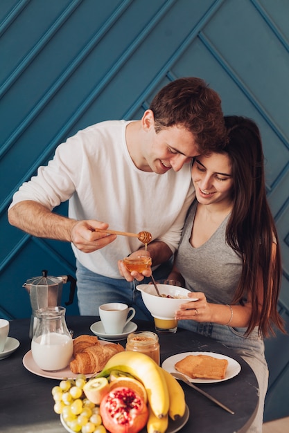 Photo gratuite jeune couple prenant son petit déjeuner