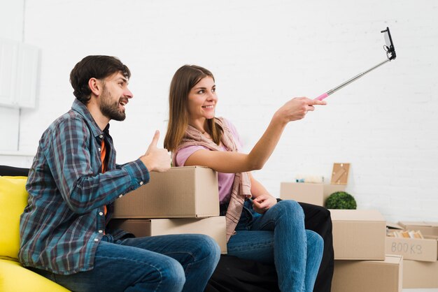 Jeune couple prenant des sulfures avec un smartphone dans leur nouvelle maison