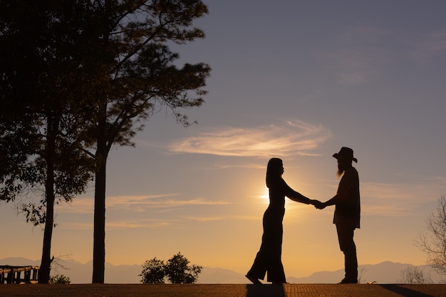 Jeune couple profitant du coucher de soleil dans la montagne