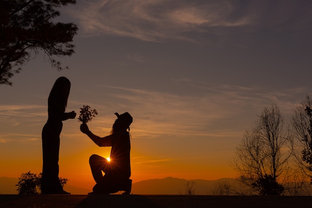 Jeune couple profitant du coucher de soleil dans la montagne