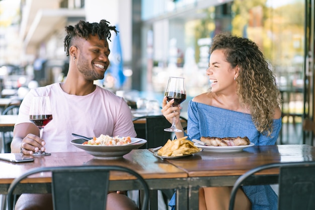 Jeune couple profitant et passant du bon temps ensemble tout en ayant un rendez-vous dans un restaurant.