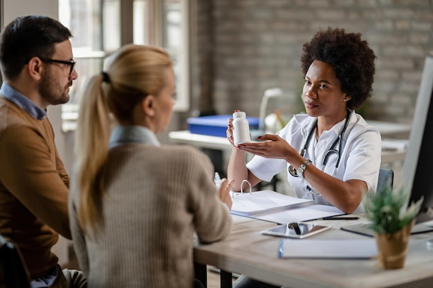 Photo gratuite jeune couple recevant des médicaments sur ordonnance d'une femme médecin lors de consultations à la clinique l'accent est mis sur le médecin