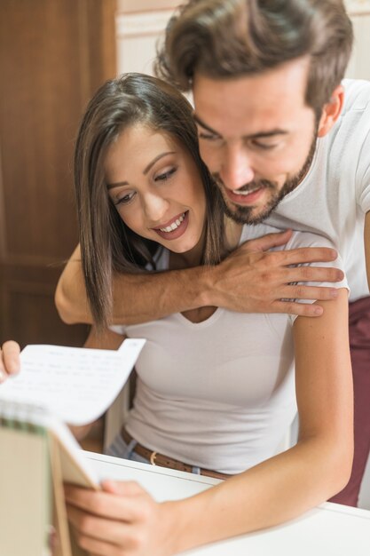 Jeune couple regardant cahier