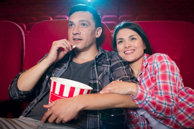 Jeune couple en regardant un film au cinéma