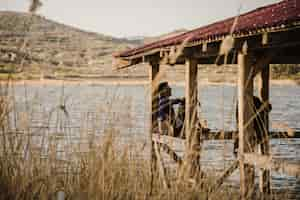 Photo gratuite jeune couple reposant près du lac