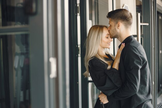 Jeune couple romantique s'embrassant à la fenêtre du café