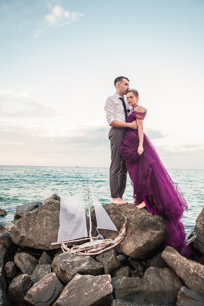 Jeune couple romantique se détendre sur la plage en regardant le coucher du soleil