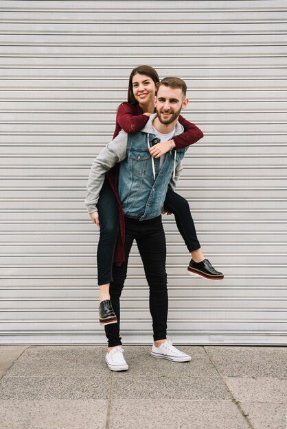 Jeune couple s&#39;amusant devant le garage