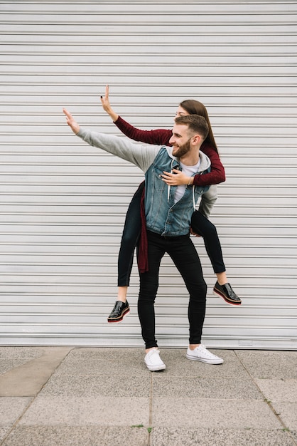 Jeune couple s&#39;amusant devant le garage