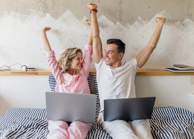 Jeune Couple S'amusant Sur Le Lit Le Matin, Tenant Les Mains En S'amusant