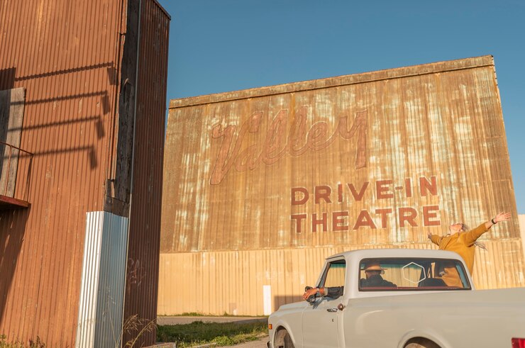 Photo gratuit jeune couple s'amusant lors de leur voyage en voiture dans un cinéma drive-in