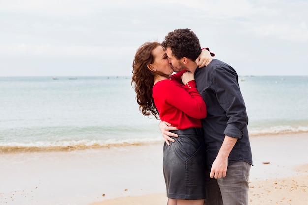 Jeune couple s'embrassant au bord de la mer