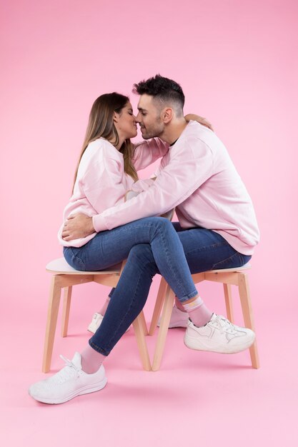 Jeune couple s&#39;embrassant sur des chaises
