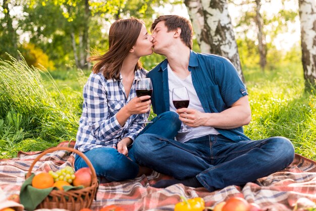 Jeune couple s&#39;embrassant sur pique-nique