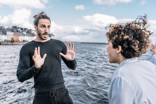 Jeune couple se disputant expressément avec la mer floue