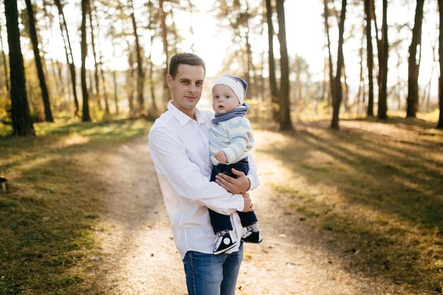 Un jeune couple se promène dans les bois avec un petit garçon