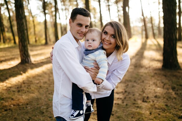 Un jeune couple se promène dans les bois avec un petit garçon