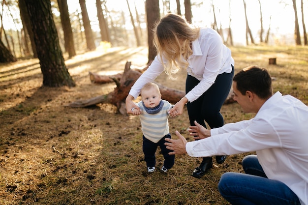 Un jeune couple se promène dans les bois avec un petit garçon