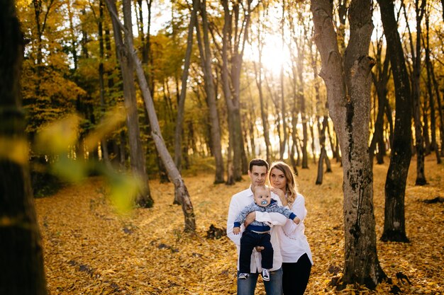 Un jeune couple se promène dans les bois avec un petit garçon