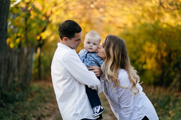 Un jeune couple se promène dans les bois avec un petit garçon