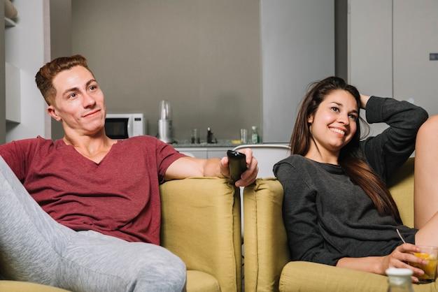 Photo gratuite jeune couple, séance, fauteuils, et, regarder télé