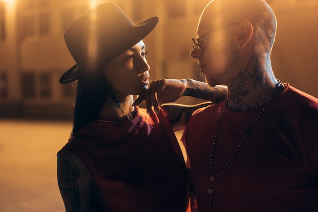 Un jeune couple sexy amoureux pose dans la rue de nuit de la ville.