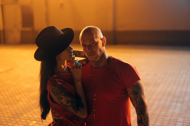 Un jeune couple sexy amoureux pose dans la rue de nuit de la ville.