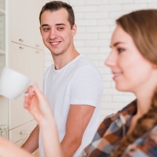 Photo gratuite jeune couple souriant dans la cuisine à la maison