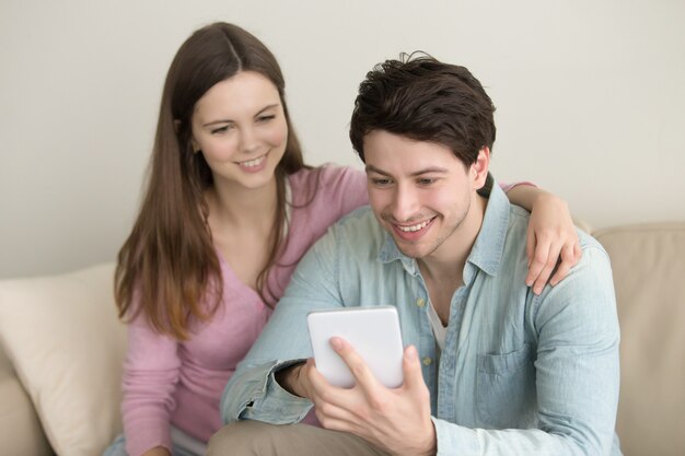 Jeune couple souriant heureux à l&#39;aide d&#39;une tablette, appel vidéo, boutique en ligne