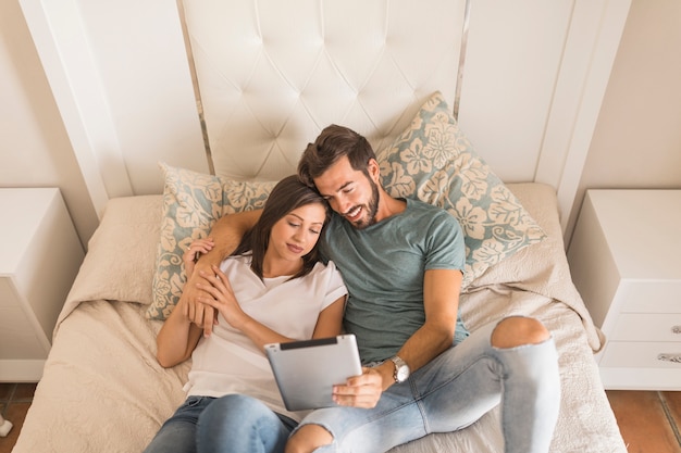 Jeune couple, à, tablette, coucher lit mou