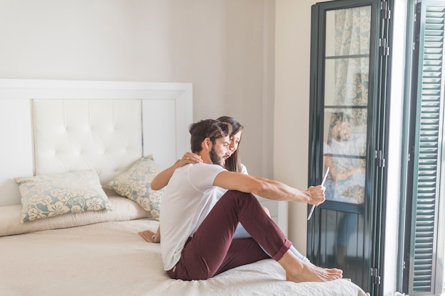 Jeune couple avec tablette dans une chambre élégante