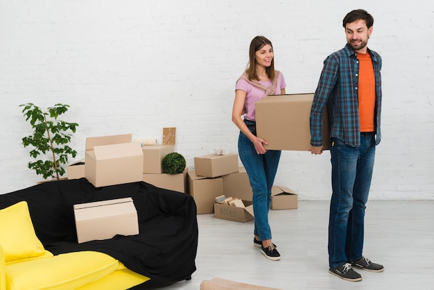 Photo gratuite jeune couple tenant la boîte en carton dans leur nouvelle maison