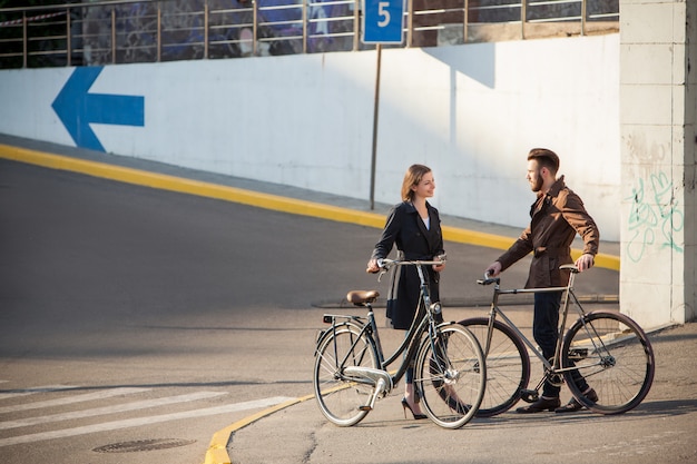 Jeune couple avec un vélo en face de la ville