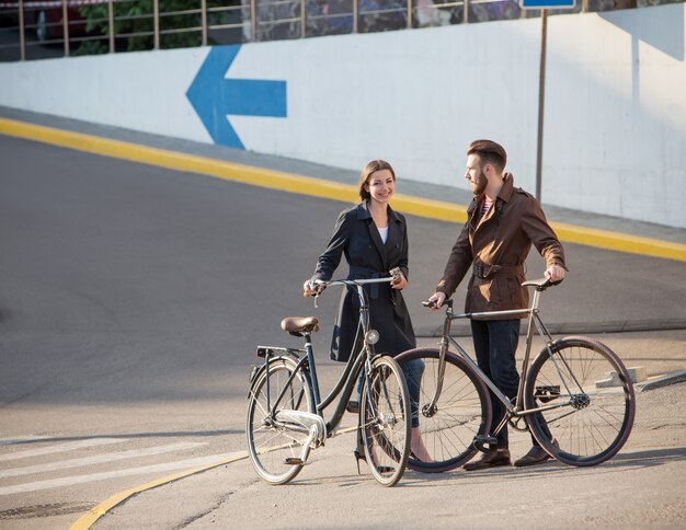 Jeune couple avec un vélo en face de la ville