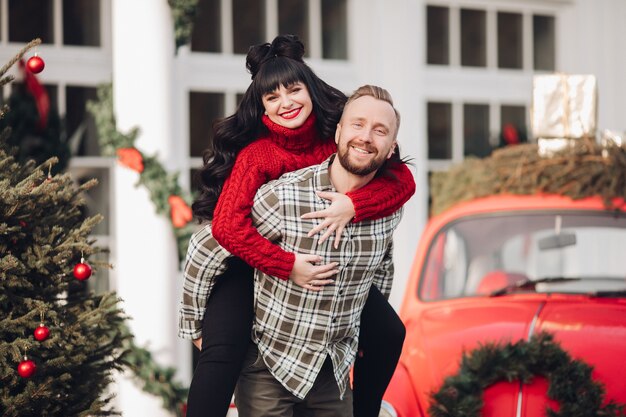 Un jeune couple en vêtements chauds s'amuse ensemble dans l'atmosphère du Nouvel An à l'extérieur