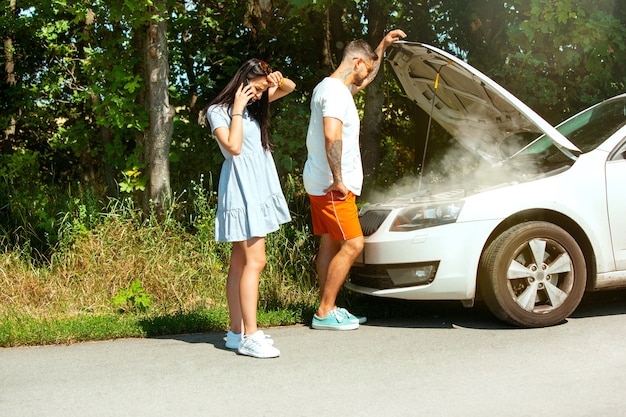 Jeune couple voyageant sur la voiture en journée ensoleillée