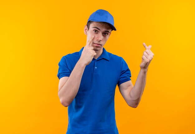 Jeune courrier portant l'uniforme bleu et bonnet bleu faisant face malheureuse et montre de l'argent avec les doigts