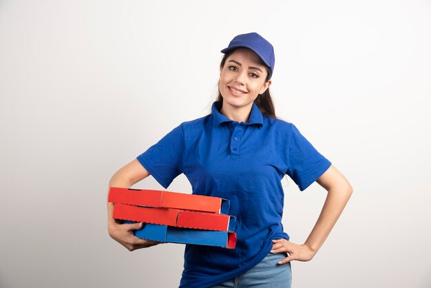 Jeune coursier féminin avec carton de pizza et presse-papiers