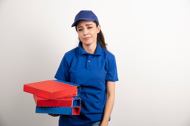 Jeune coursier féminin avec carton de pizza et presse-papiers