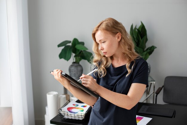 Jeune créatrice de logo féminin travaillant sur une tablette graphique