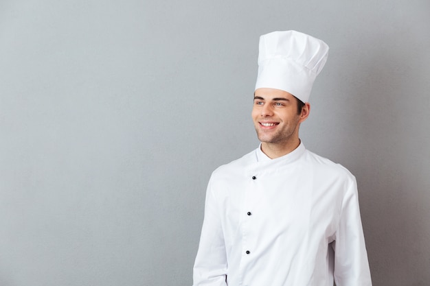 Jeune cuisinier en uniforme debout isolé