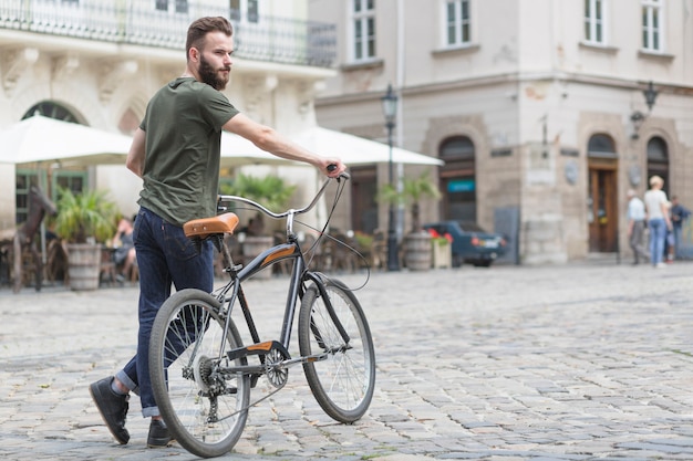 Jeune cycliste avec son vélo dans la rue